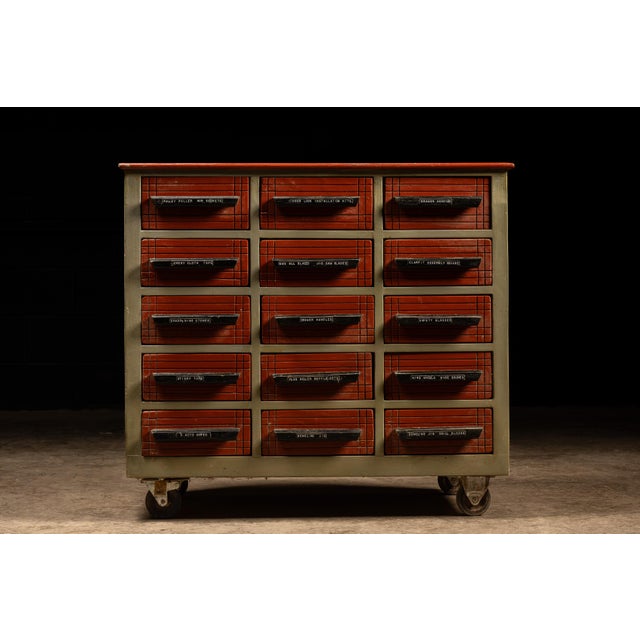 Vintage rolling wooden parts cabinet. This piece features 12 drawers of uniform size, plus an additional three smaller...