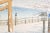 A serene snowy winter's day with bare trees, a pergola, and a hazy view of the mountains in the background this original...
