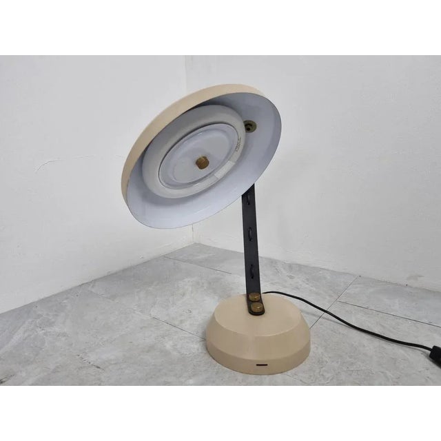 Vintage adjustable desk lamp with a neon light bulb. Beige and black metal base and lamp shade with brass details. Nice...