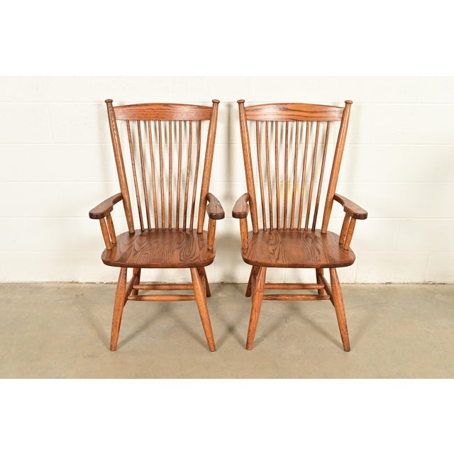 A gorgeous pair of American Colonial or Arts & Crafts style solid oak spindle back Windsor armchairs or dining captain...