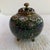 A beautifully detailed vintage Chinese cloisonné covered jar featuring a vibrant phoenix bird amid a lush floral ground in...