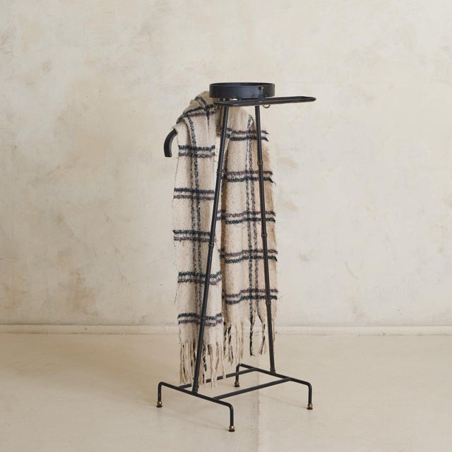 A French valet from the 1950s by Jacques Adnet reflects a refined approach to utility, where structure, material, and...