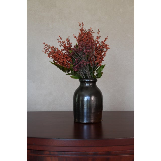 A small vintage stoneware jar in a deep olive-black glaze. Use it as a bud vase for a single stem or sprig of herbs, or...