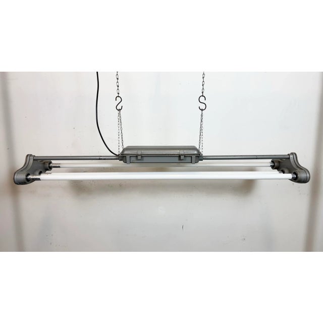 This industrial tube light was made by polam gdansk in poland during the 1970s. It features an aluminium body in grey...