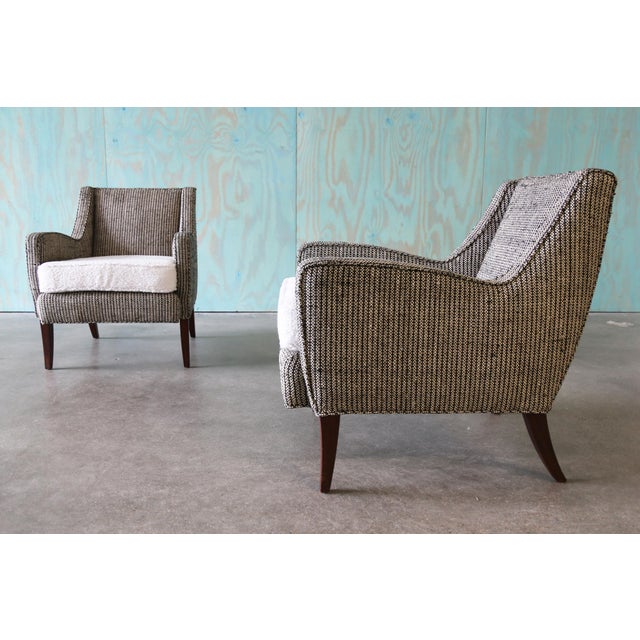 A pair of 1950s club chairs in black and white textured wool with white boucle cushions. These chairs are an unknown maker...