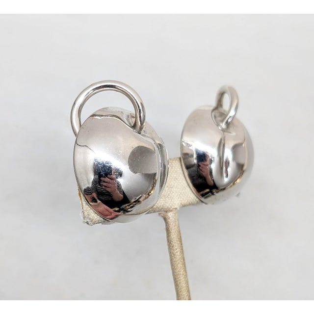 Rhodium plated smooth round domed apples with curled stem top clip earrings. Marked "NAPIER PAT. PEND." on the clips and...