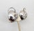 Rhodium plated smooth round domed apples with curled stem top clip earrings. Marked "NAPIER PAT. PEND." on the clips and...