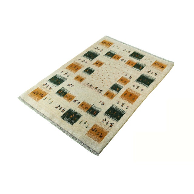 A charming hand-knotted Gabbeh nomad rug with traditional symbolism and natural color schemes. The graphic panels...