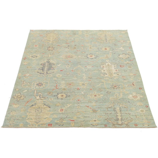 Enhance your space with this Modern Oushak Style Wool Rug, featuring a serene sage green field and oversized floral...