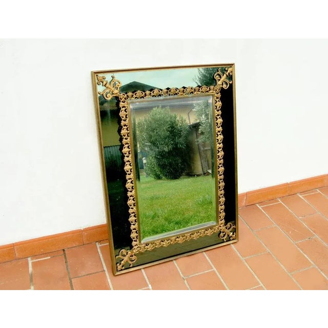 Beautiful vintage mirror with elegant brass decorations. The 'object has a green-colored perimeter mirror with a brass...