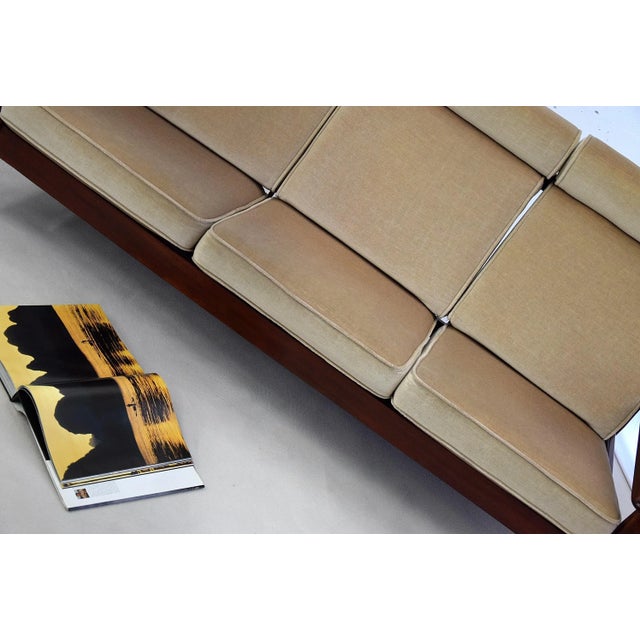 This comfortable and stylish large 3-seater sofa is made of mahogany and was produced in the 1960s. It is made in the...