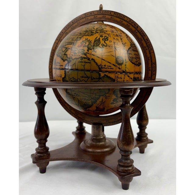 Vintage Italian globe featuring an Old World–style map with richly detailed zodiac and celestial motifs, set upon a turned...