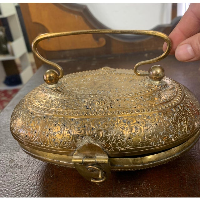 This elegant vintage brass metal purse features intricate all-over engraved floral and scrollwork detailing, showcasing...
