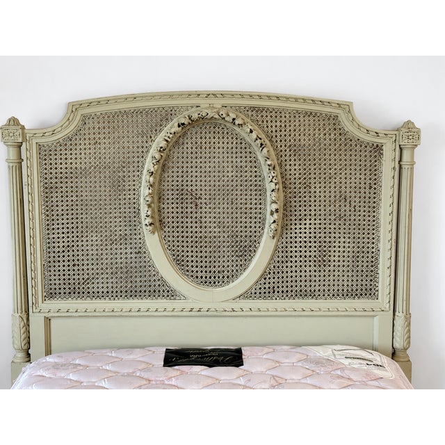An exquisite pair of antique French Louis XVI–style twin beds, featuring beautifully carved wood frames, delicate cane...