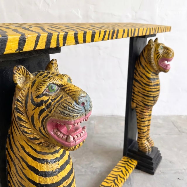 A distinctive vintage wooden console table, hand-painted in a bold tiger-stripe pattern with two sculptural tiger figures...