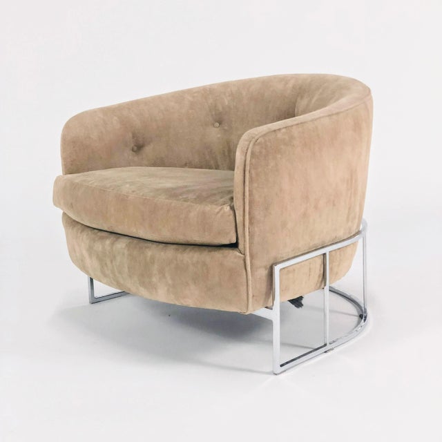 An open frame barrel back lounge chair on a chrome base, and upholstered in beige velour with tufting. Designed by Milo...
