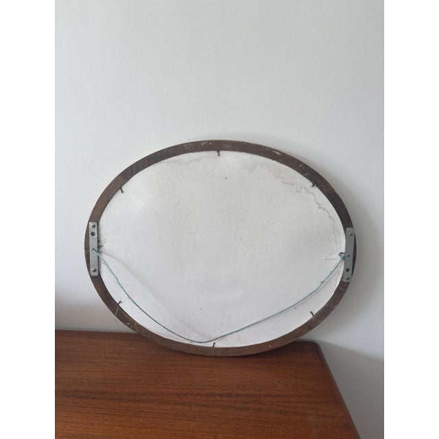 Charming antique oval mirror with a wooden frame and gilt stucco, adorned with elegant foliate motifs. A beautiful...