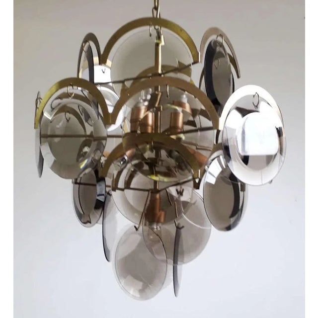 Vintage Italian chandelier with five tiers of smoky beveled glass discs mounted on brass frame, with a half moon brass...