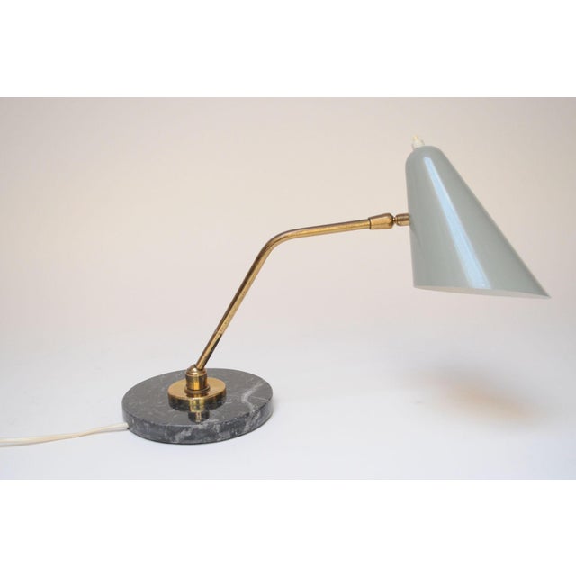 Elegant articulating table lamp by Luci Milano (ca. 1950s, Italy) Composed of a brass pivoting stem and adjustable gray...