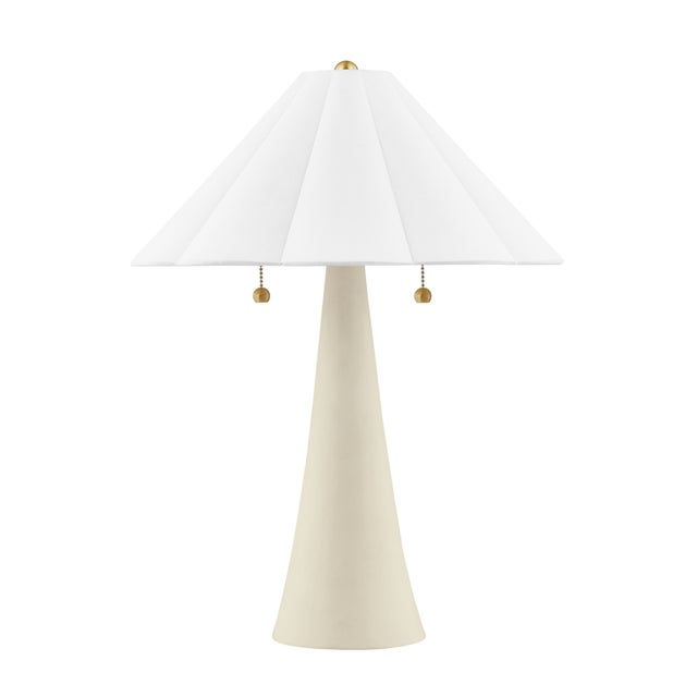 Alana keeps things light and airy. A pretty scalloped shade in white linen is adorned by aged brass accents like metal...