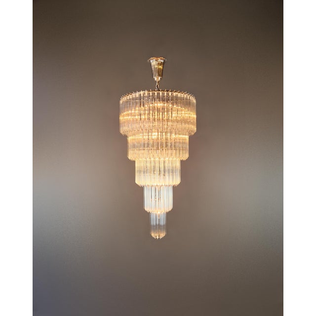 This elegant chandelier impresses with its clean, tiered design and is stylistically reminiscent of Art Deco. The multi-...