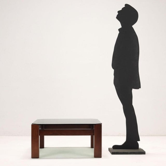 Coffee table in stained beech wood, smoked glass top. This piece is attributed to the mentioned designer/maker. It has no...