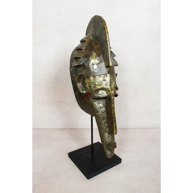 A hand-carved marka mask from mali, embellished with metalwork and hand-applied fabric tassels. Marka masks like this...