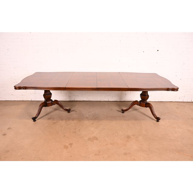 An exceptional French Regency Louis XVI style double pedestal extension dining table In the manner of Baker Furniture USA,...
