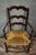 Antique solid wood armchair with a woven straw seat, in a rustic/provincial style. Three-slatted, shaped backrest, turned...