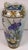 A beautifully detailed antique Japanese porcelain vase featuring an elegant hand-painted scene of colorful iris flowers...