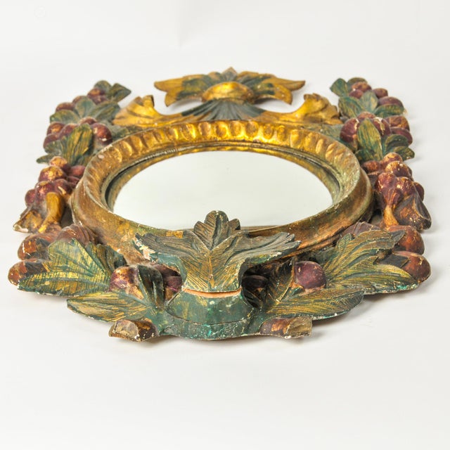 Exceptionally unique antique gilded wood hand carved convex "witch's eye" mirror with fruits and leaf design in gold, red,...