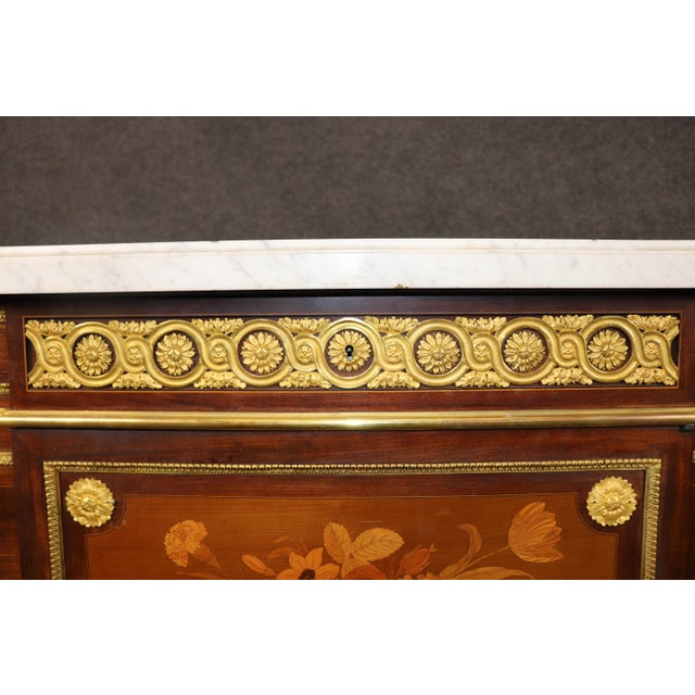 Presenting a spectacular signed Lexcellent Louis XVI–style commode, richly adorned with intricate marquetry inlay, doré...