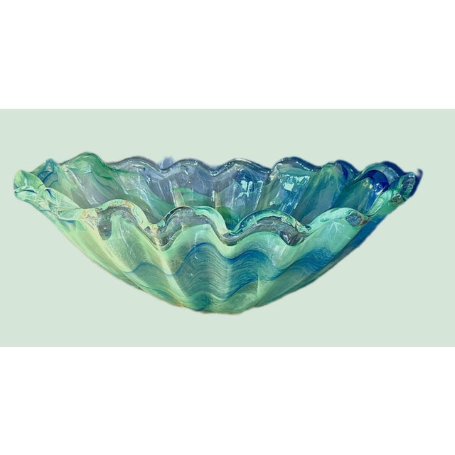 Stunning vintage Murano style hand-blown glass bowl. Features a beautiful swirl pattern in blue and teal. The ruffled top...