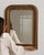 Carved giltwood mirror in Antique Gold. Finished in antique gold, this carved giltwood mirror is distinguished by molded...