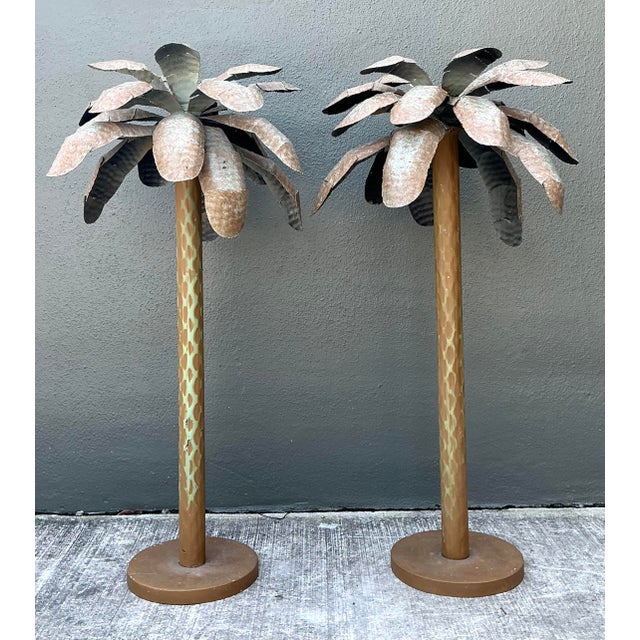 This striking pair of vintage palm tree sculptures is a masterful expression of Hollywood Regency flair and artisanal...