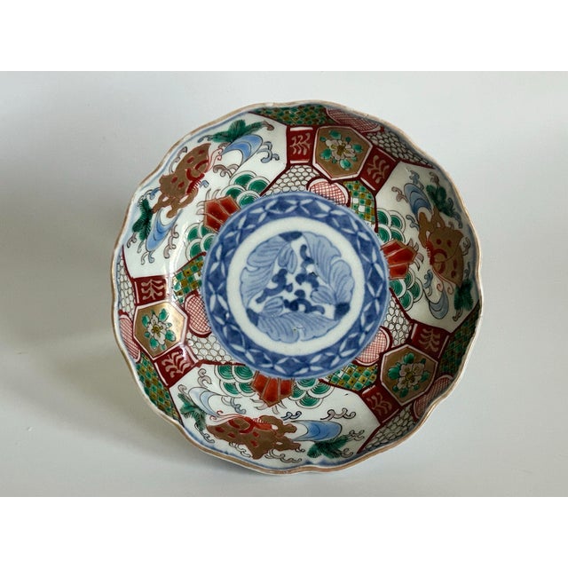 An antique Japanese Imari porcelain bowl from the Meiji period (1868–1912), featuring underglaze cobalt blue with...