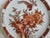 Brick red floral with bird chinoiserie platter. Made in Hong Kong and measuring 10" x 3/4". Perfect as a decorative plate...