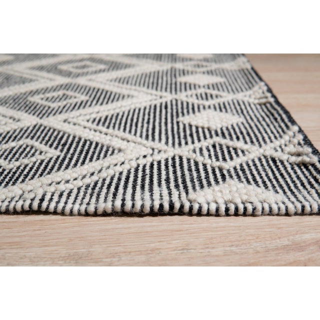Modern Kilim Black Handmade Wool Rug, Country of Origin: India. This striking flat-woven piece showcases the enduring...