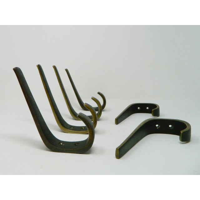 Six large, high-quality coat hooks from the Hagenauer workshops in Vienna. These hooks are made of cast brass and have a...