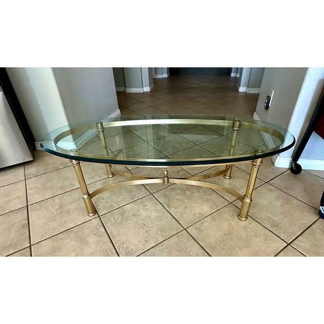 Vintage Mid-century Hollywood Regency style oval coffee or cocktail table with made of solid brass base and beveled glass...