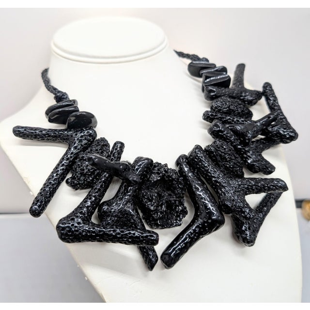1980s black resin "coral" collar necklace on a twisted cord with rhodium plated box clasp. Marked "U. CORREANI MADE IN...