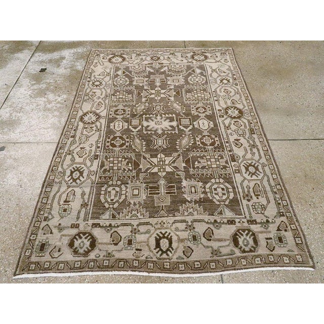 This mid-20th-century Persian Malayer rug presents a strongly geometric composition in muted brown, taupe, ivory, beige,...