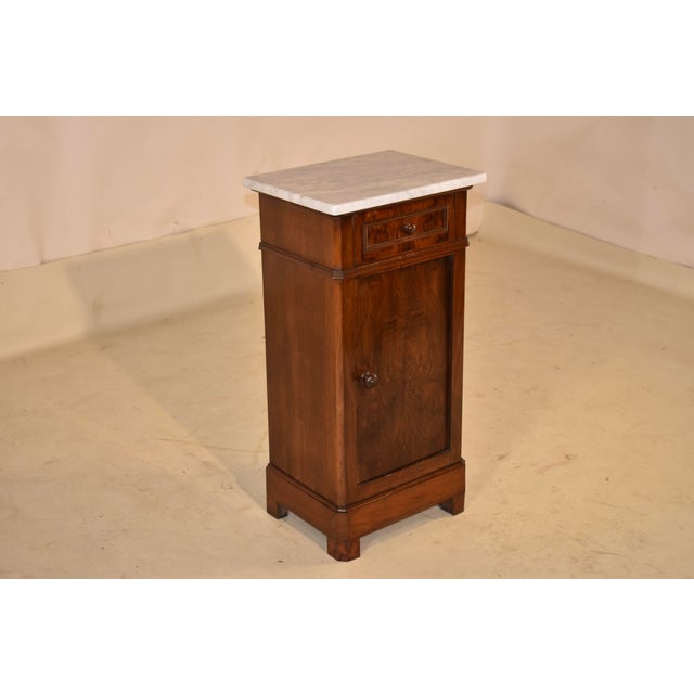 19th century walnut bedside cabinet with a Carrara marble top from France. The Carrara top has been replaced and follows...