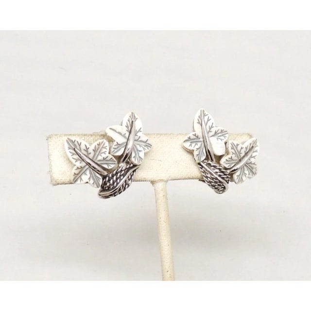 This is part of Chairish’s Costume Jewelry assortment. Rhodium plated white thermoset leaves with darkened veins clip back...