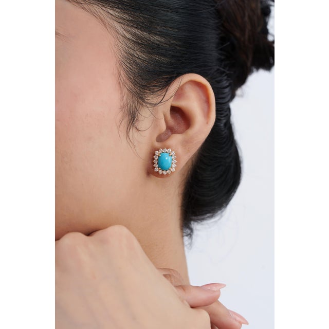 These stud earrings feature 4 carats of vibrant cushion-cut natural turquoise, set in 14k yellow gold. The center stones...