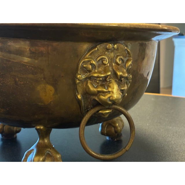antique footed brass jardiniere with lions heads and handles about 12.5 w. x 7 h. very solid; normal wear for age charming...