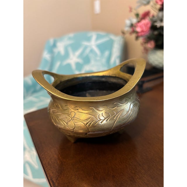 A charming vintage brass censer or incense burner featuring traditional Asian-inspired styling with twin open handles,...
