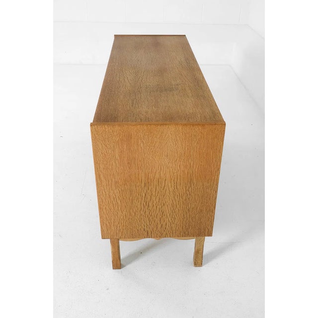 A handsome oak sideboard from Denmark, circa 1970s, executed in the style of Henning Kjærnulf. The piece carries the...