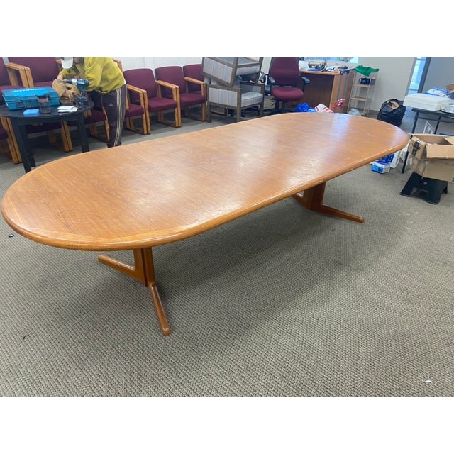 This vintage Mid-Century Modern teak Danish Conference Table is a stunning piece of furniture made in Denmark. The oval-...