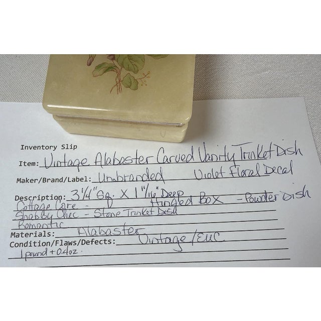 Vintage alabaster stone trinket box showcases a delicate purple floral violet motif on the lid. Crafted from smooth,...